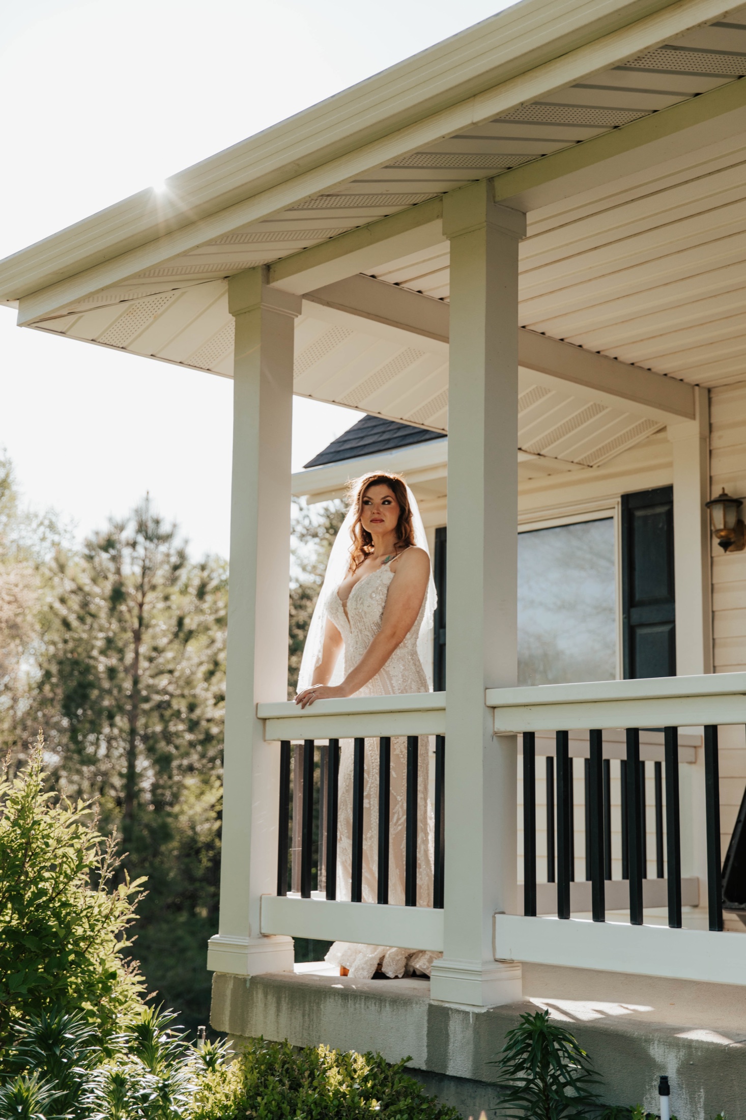 Bride in her gown on a sunlit porch